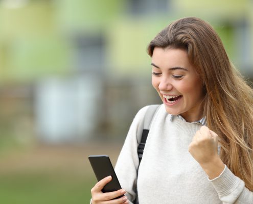 student looking at her phone excitedly