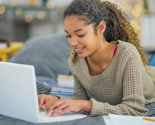female high school student studying with laptop